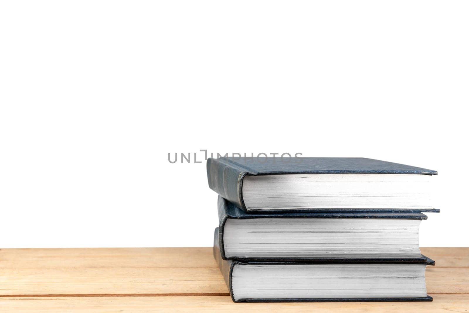 Pile of books on wooden table isolated over white background. Back to School concept
