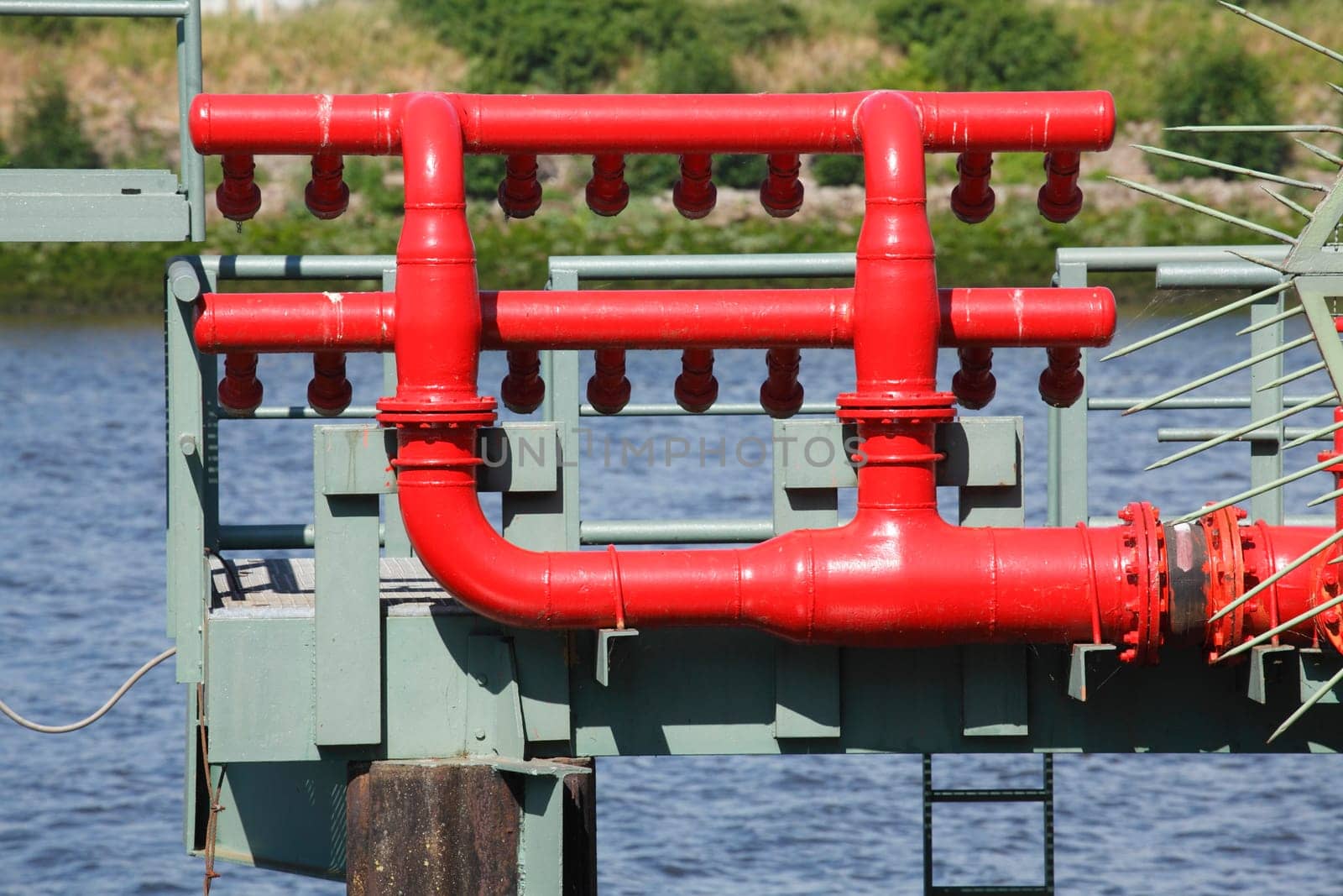 Red metal pipes for refueling ships at a pier, Germany, Europe