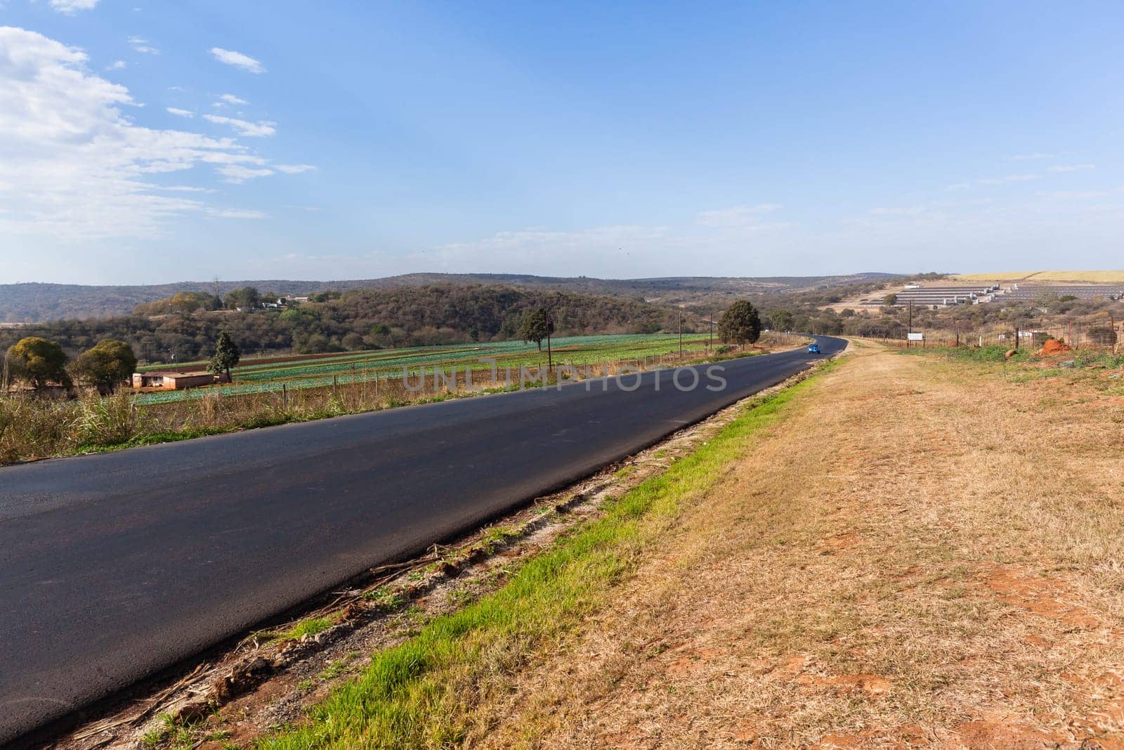 Countryside industrial new tarred asphalt surface on road  route through rural farming landscape