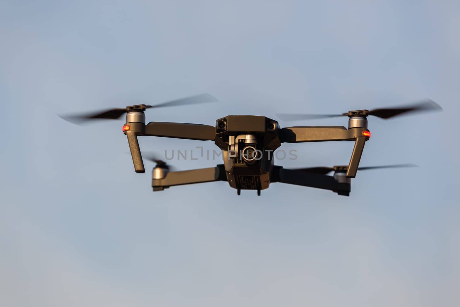 Drone aircraft with video camera flying closeup blue sky.