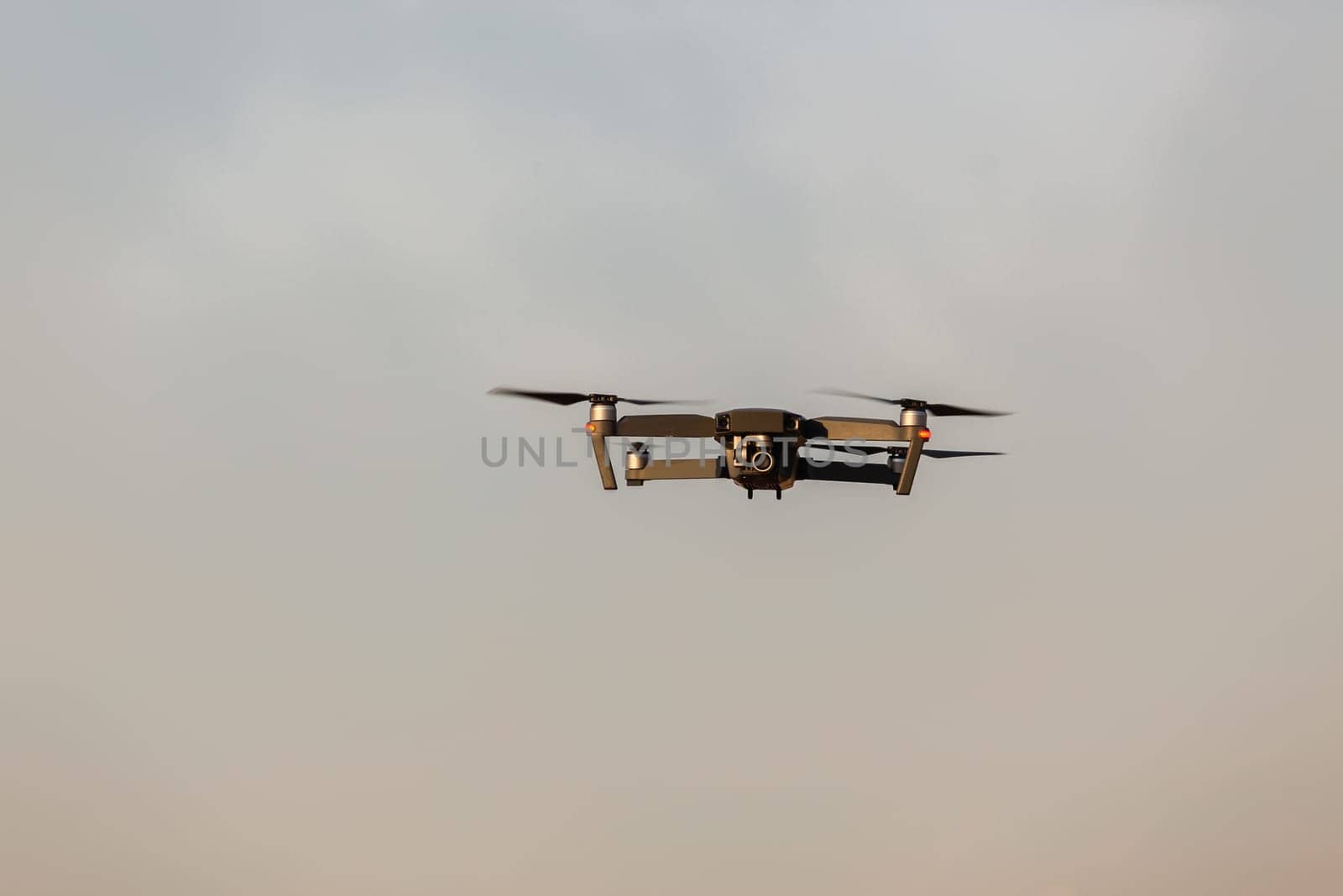 Drone aircraft with video camera flying closeup blue sky.