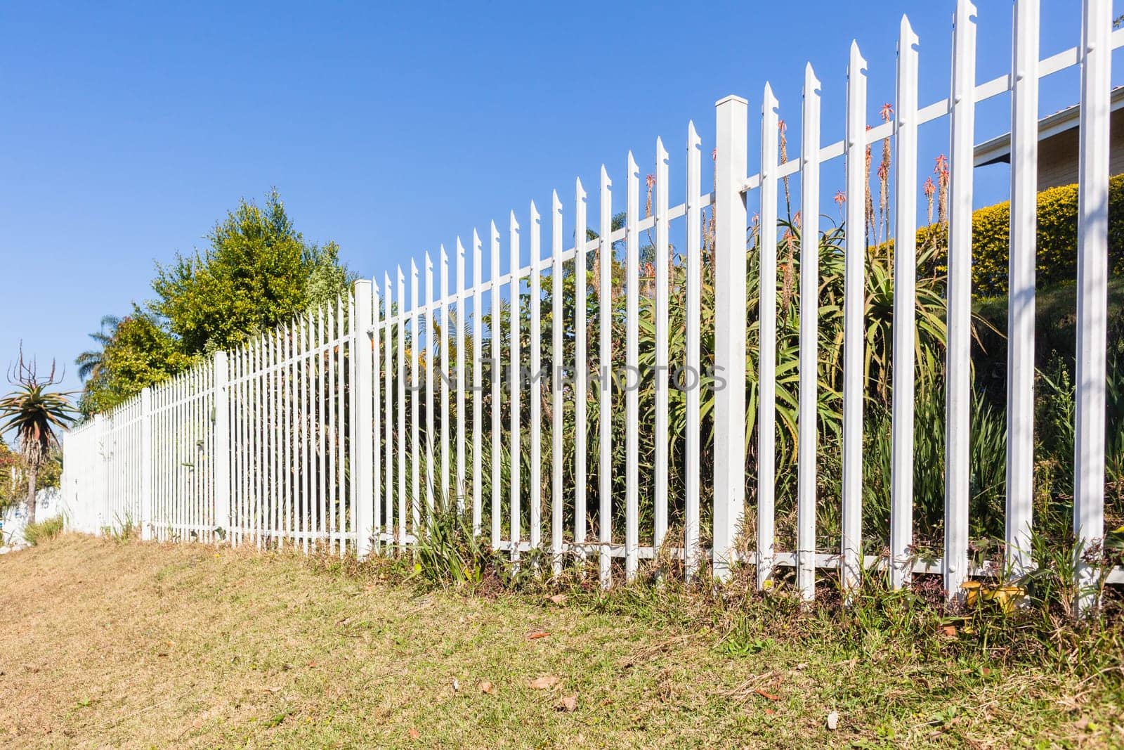 Fence steel white boundary structure closeup on boundary of  property.