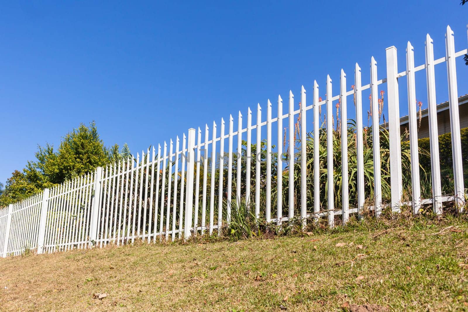Fence steel white boundary structure closeup on boundary of  property.