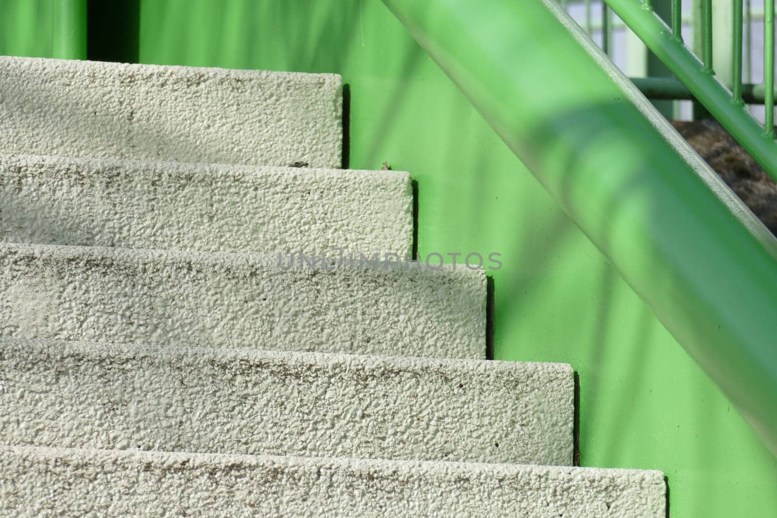 Concrete staircase and green stair railing