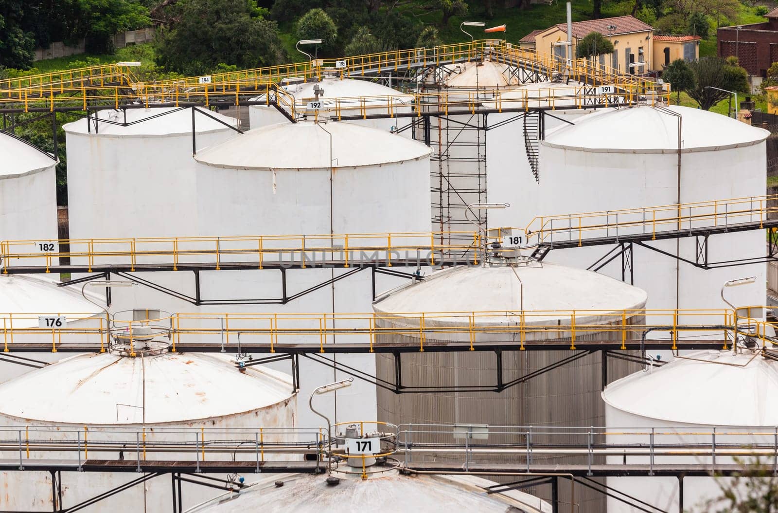 Storage steel industrial liquids oils tanks depot for fuels chemicals overlooking structures.