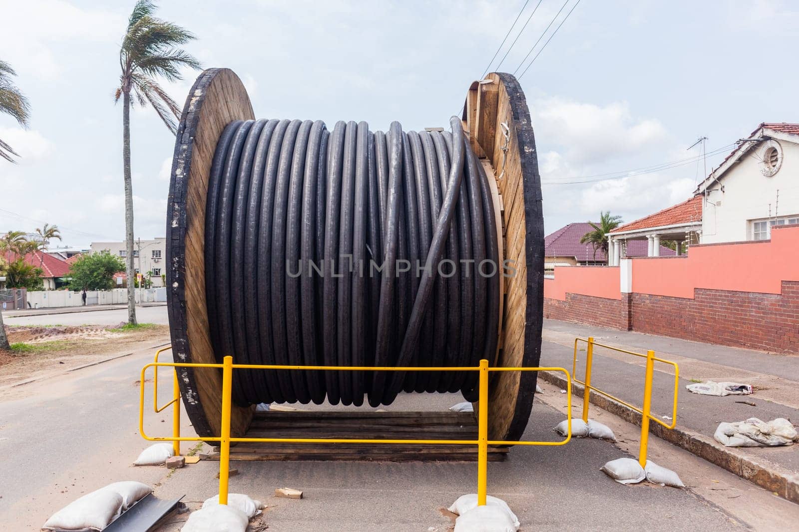Electrical new high voltage cables on large wood drums been installed in underground Trenches industrial construction project.
