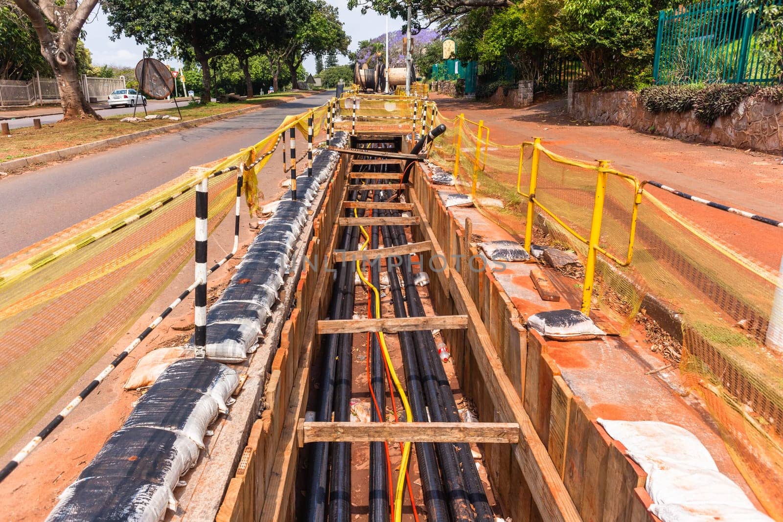 Electrical new high voltage cables been installed in underground trenches industrial project closeup photo.