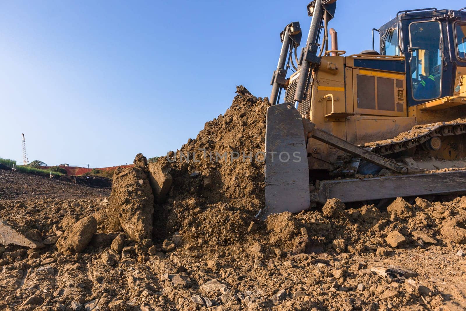 Construction industrial earthworks landfill dozer machine scoop bucket moving sand stones closeup abstract.