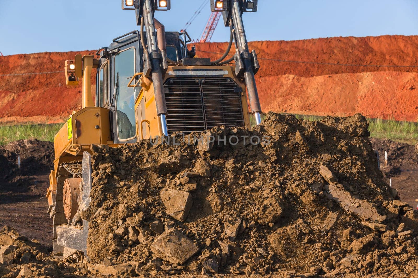 Construction industrial earthworks landfill dozer machine scoop bucket moving sand stones closeup abstract.