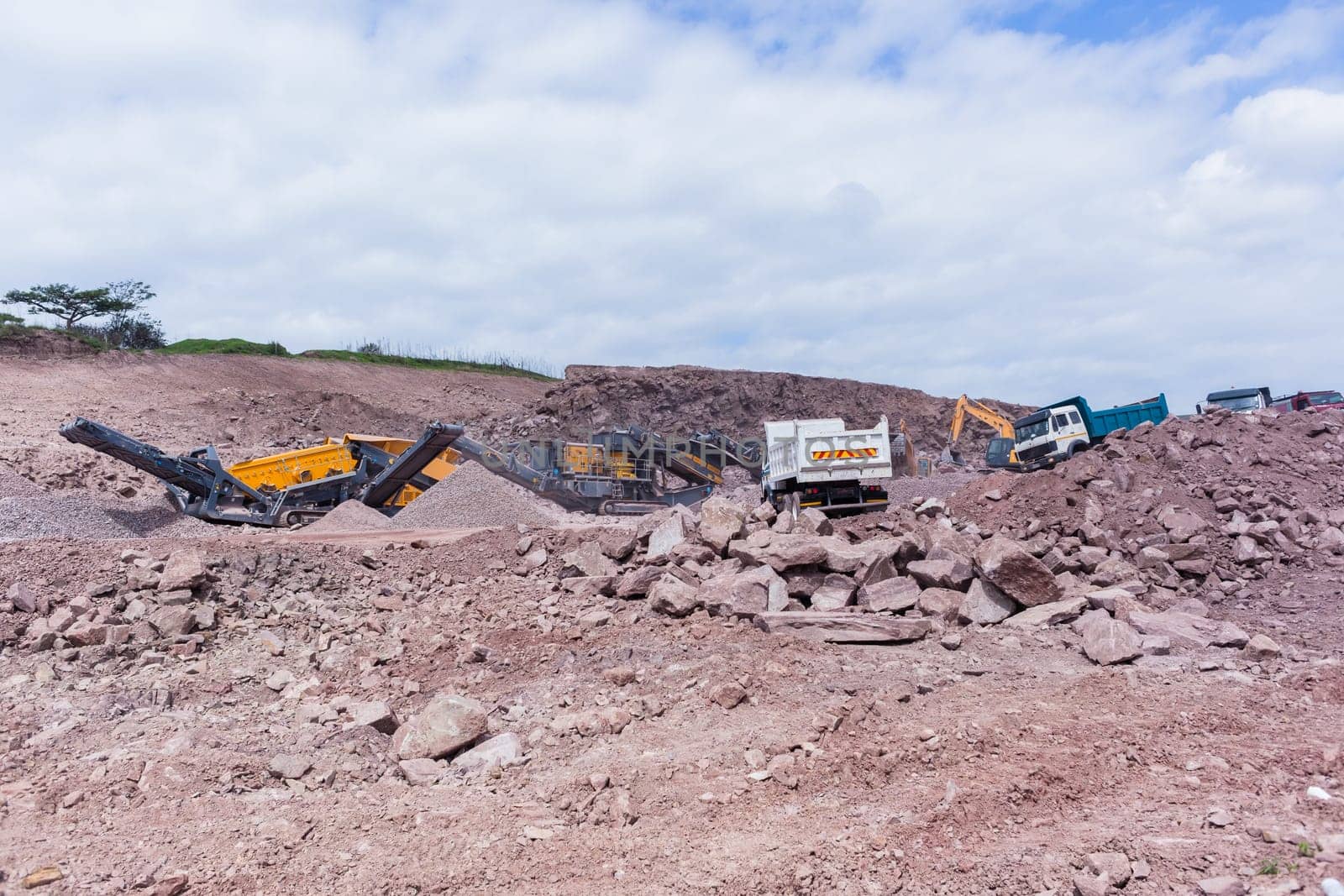 Construction mobile industrial quarry stone crushing machines producing mix grades for concrete cement on building site.