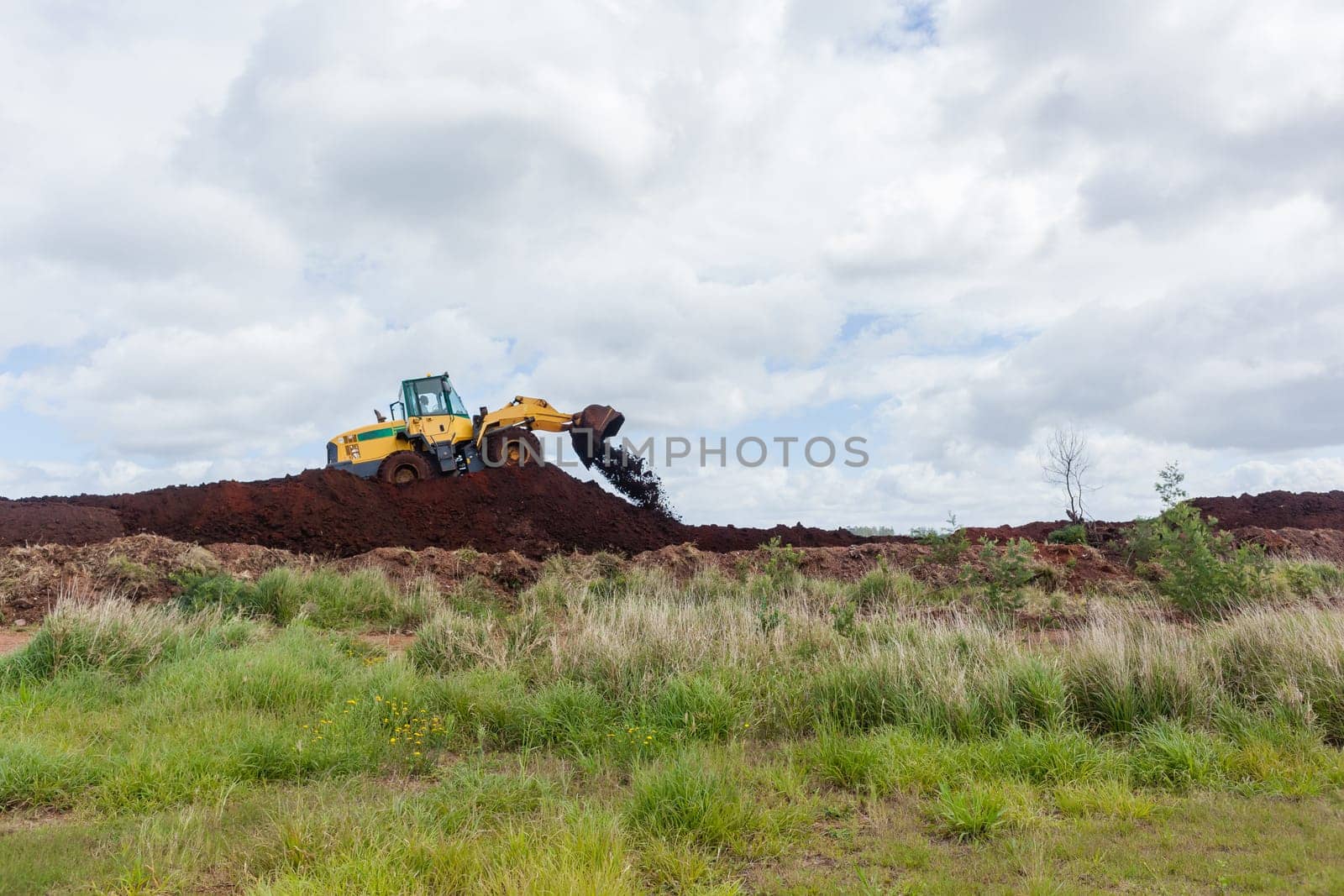 Industrial earthworks industrial vehicle loader bucket machine on building construction site.