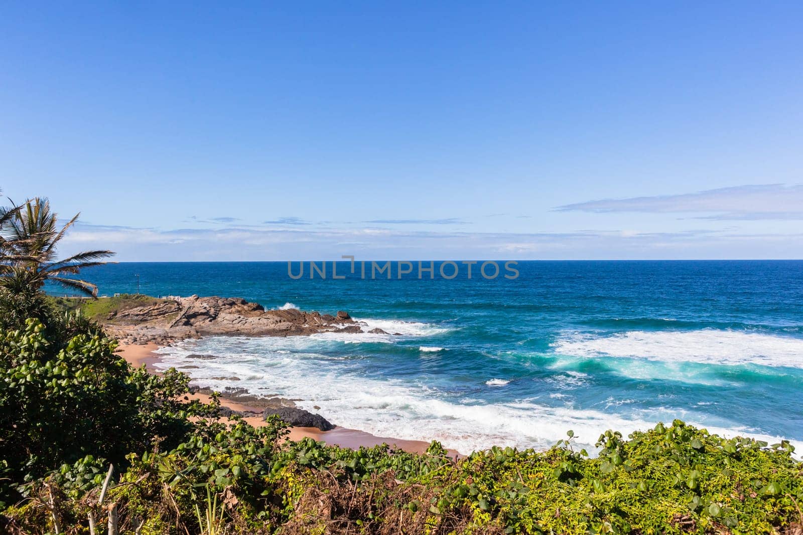 Beach ocean waves rocky coastline horizon summer blue holiday landscape.