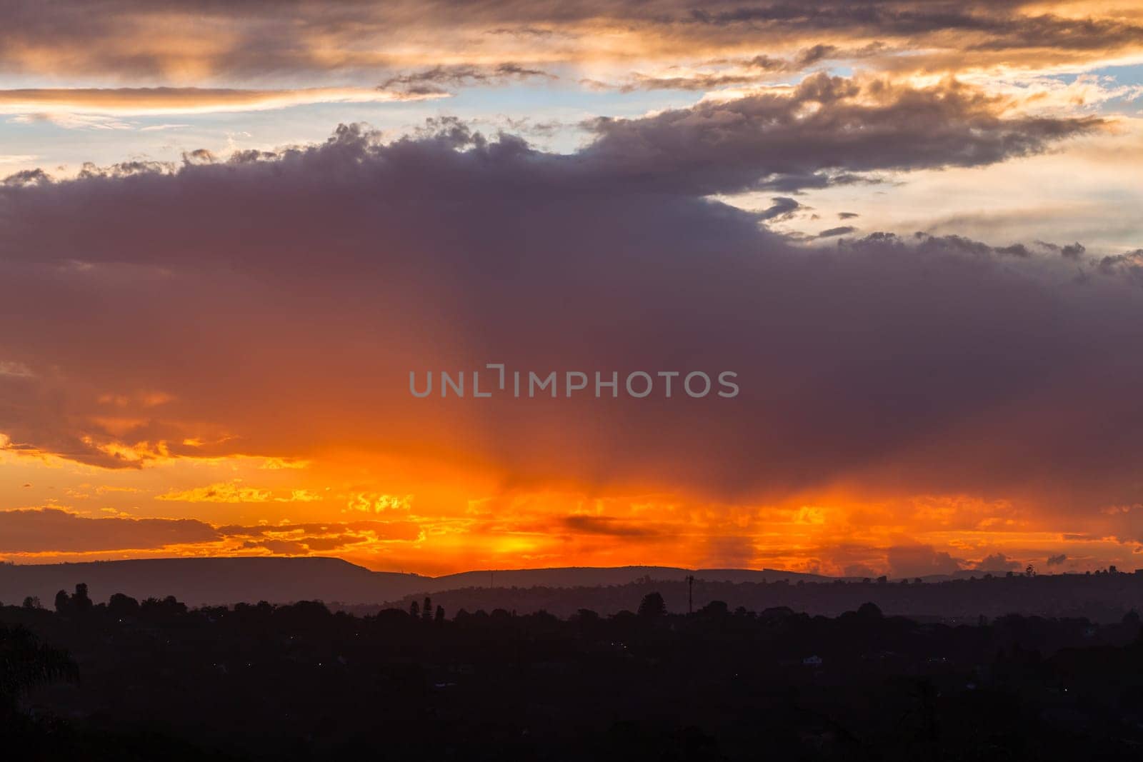 Sunset sundown clouds color contrasts over countryside hills homes a scenic landscape