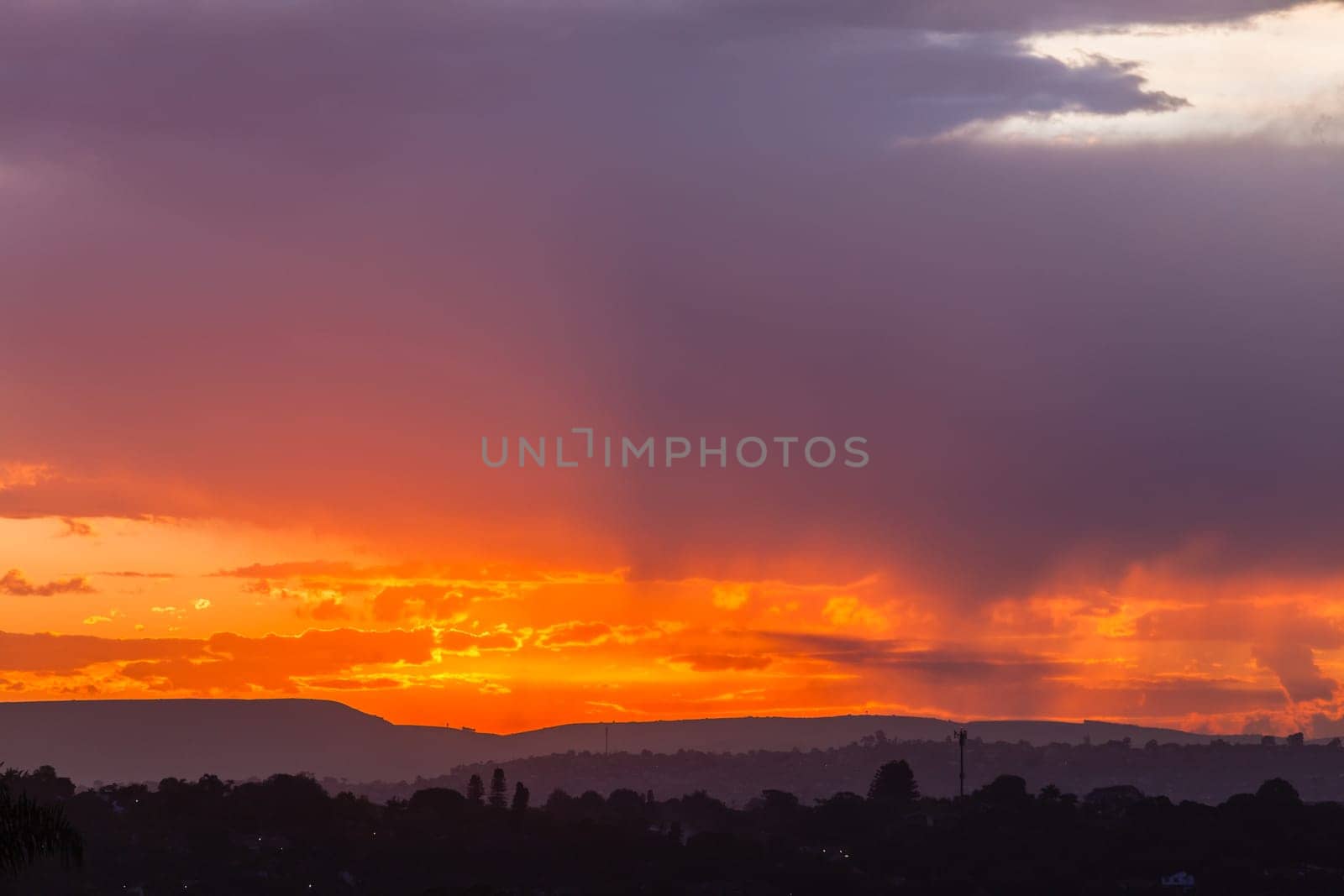 Sunset sundown clouds color contrasts over countryside hills homes a scenic landscape