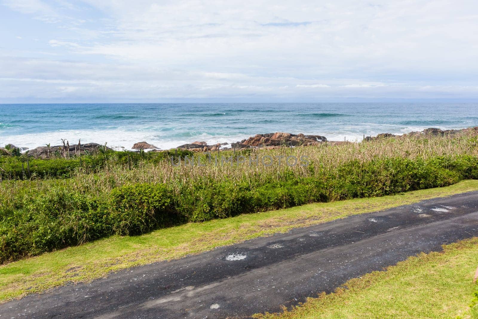 Beach road with ocean waves rocky coastline scenic holiday landscape