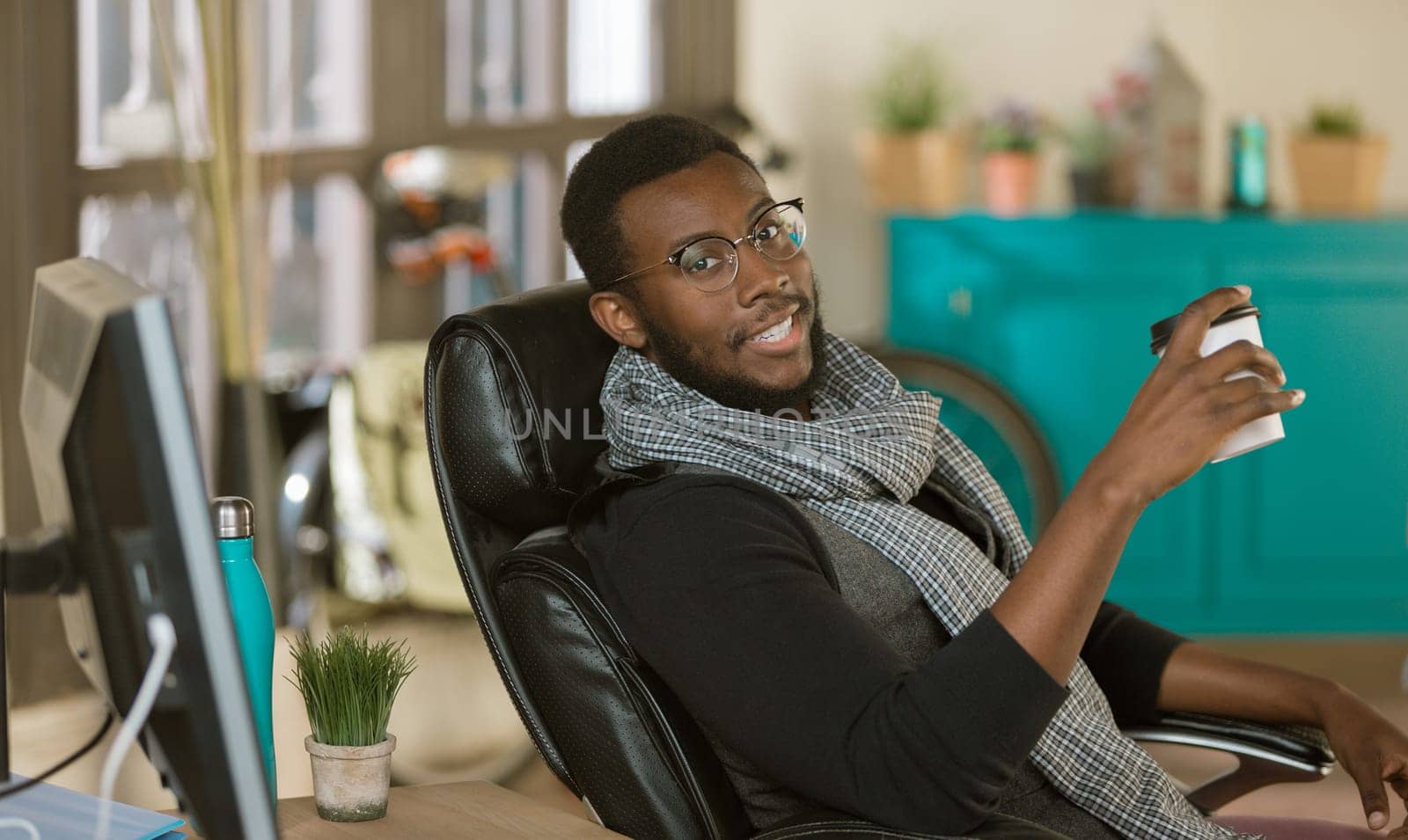 Handsome professional man in a creative office with coffee