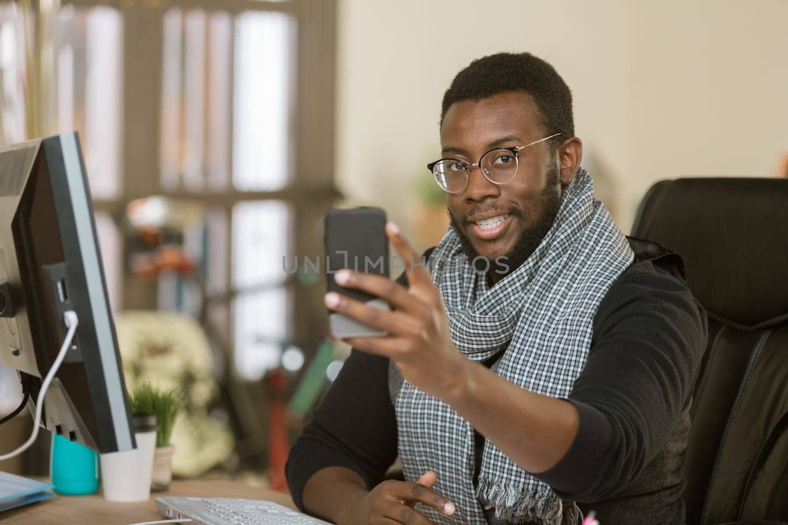 Handsome professional man in a creative office using his mobile device