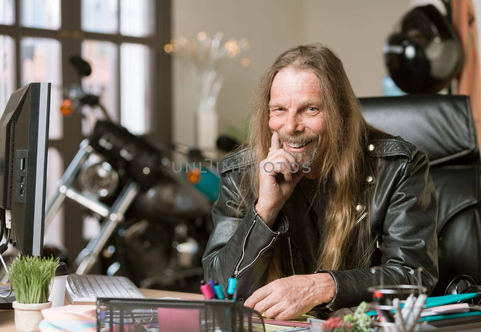 Happy man at his desk with a motorcycle