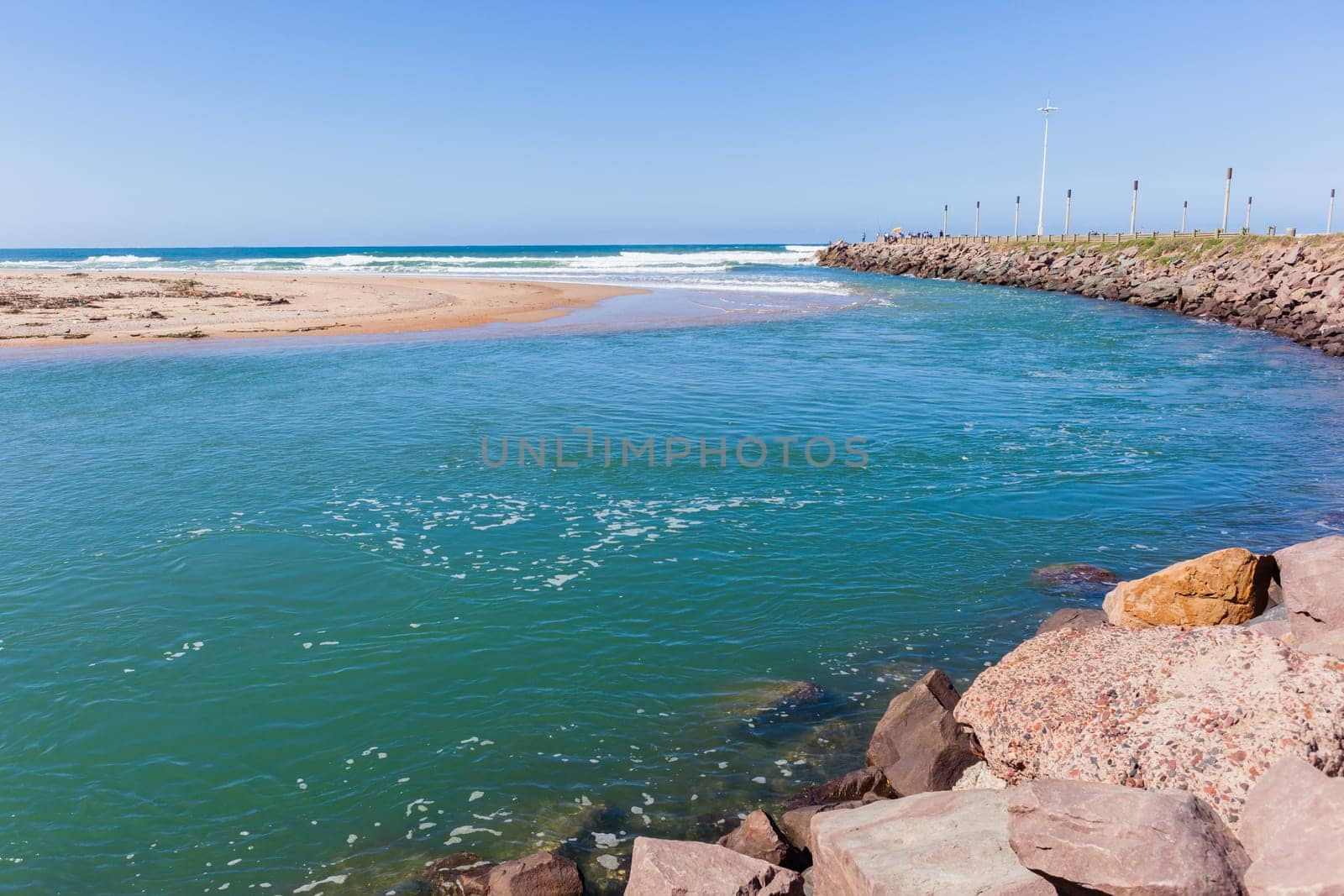 Beach river-mouth ocean waves along rocky coastline scenic summer landscape.