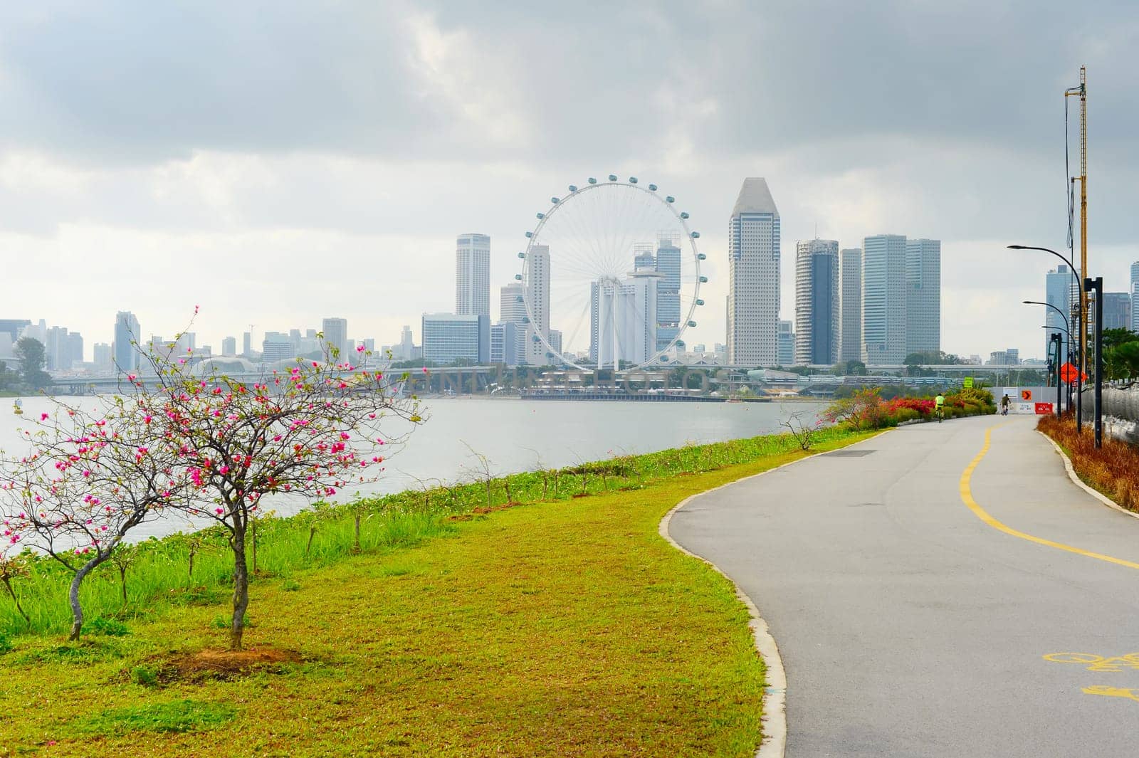 View of Singapore riverbank in Marina Barrage - popular place for workout and sport exercices. Singapore Flyer in the background