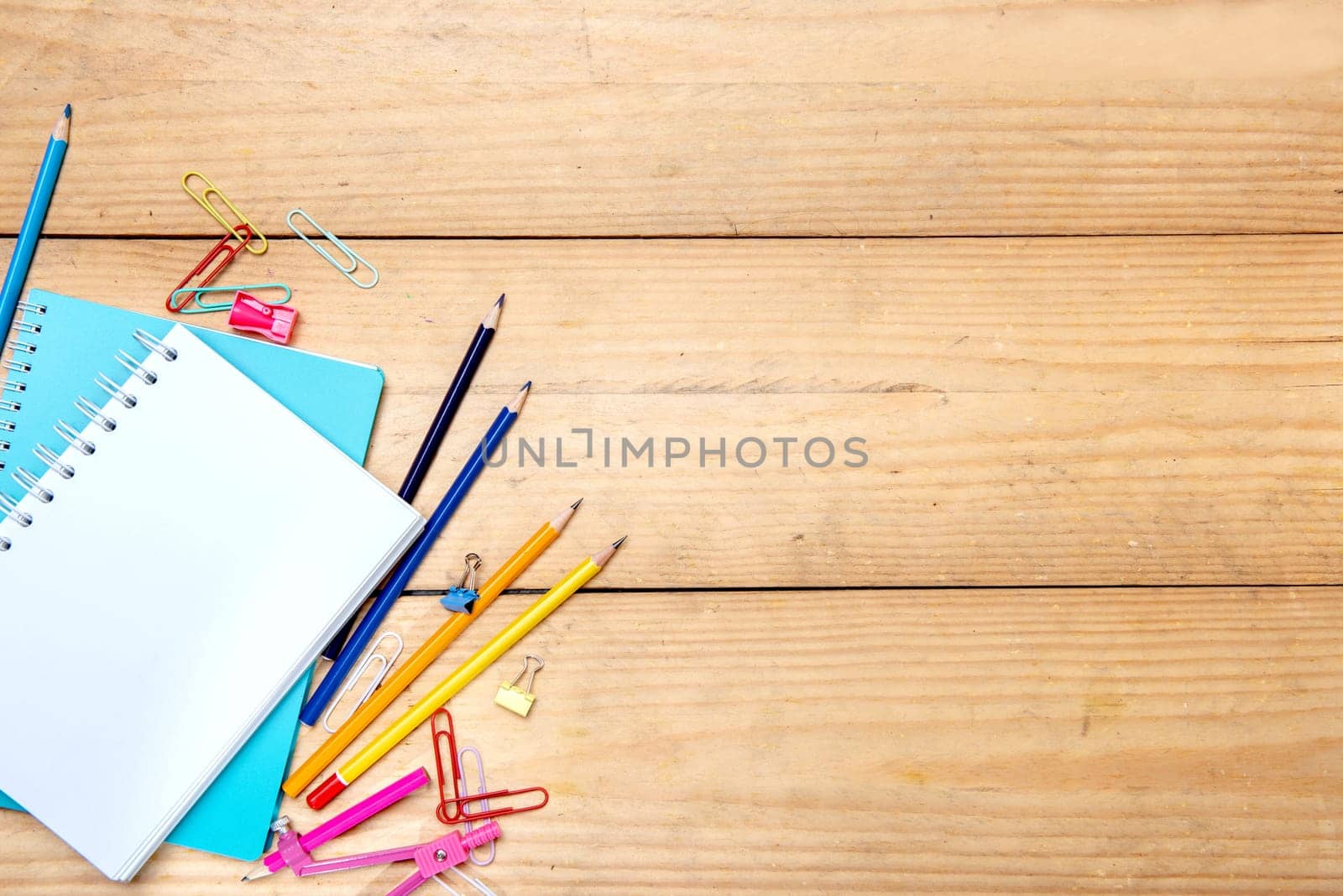 Notebooks with school supplies and stationery on the wooden table. Back to School concept