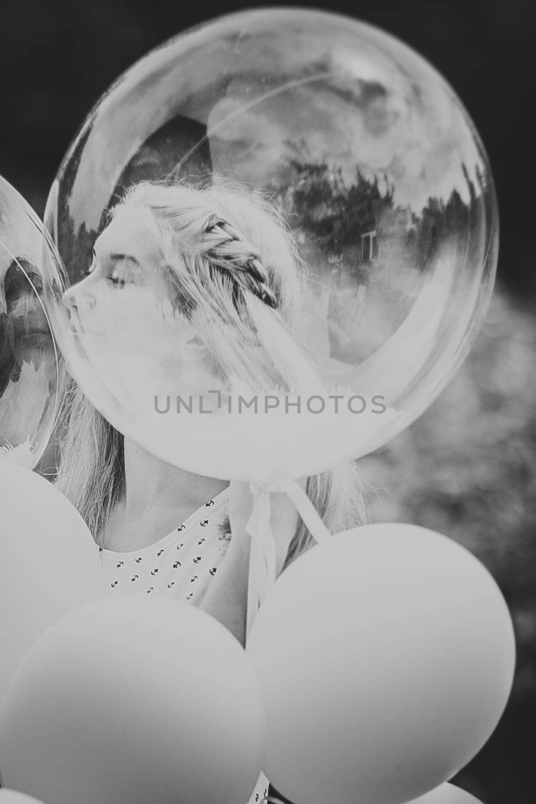 black white photo young girl with balloons on nature background.