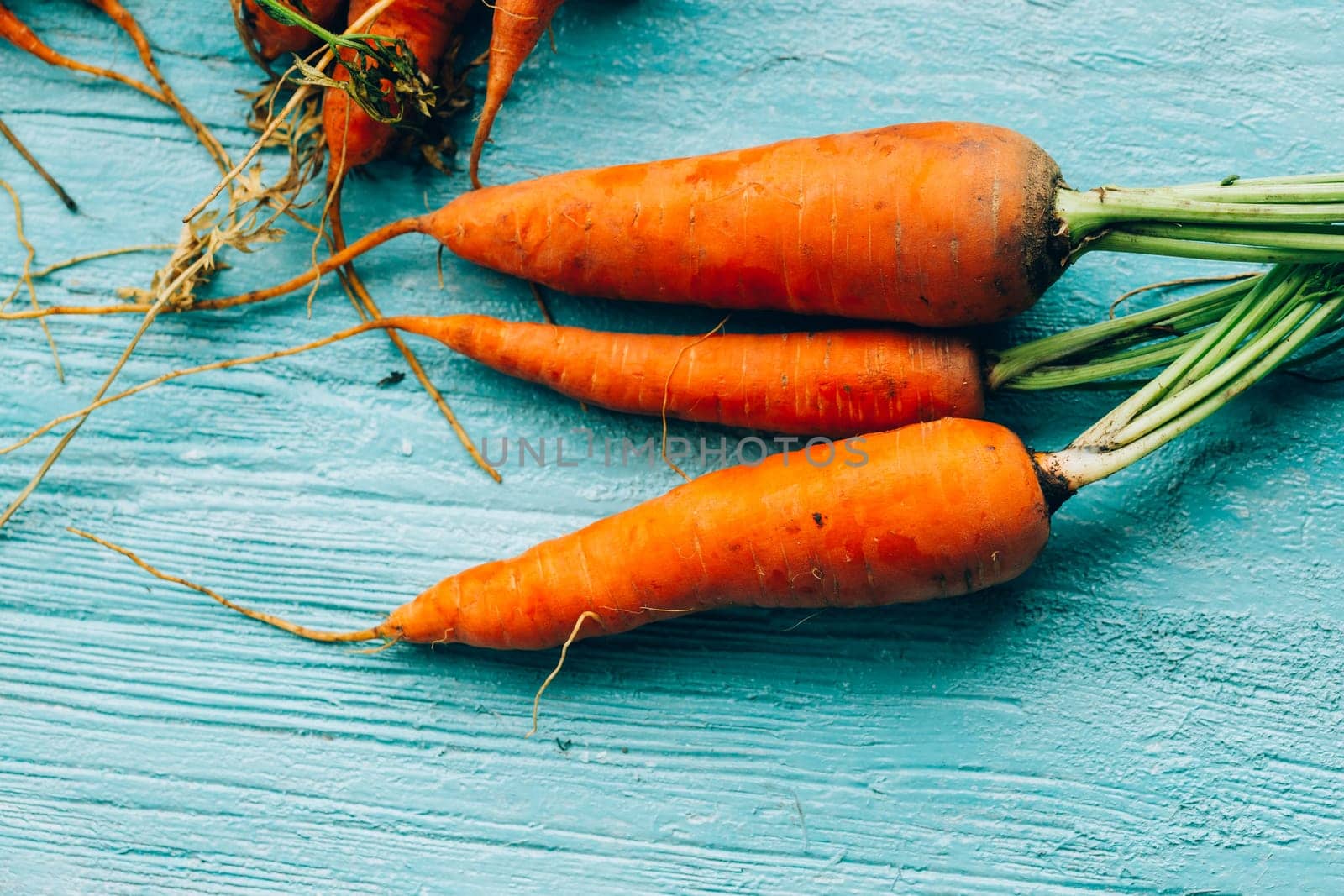 lot of carrots on a wooden background.