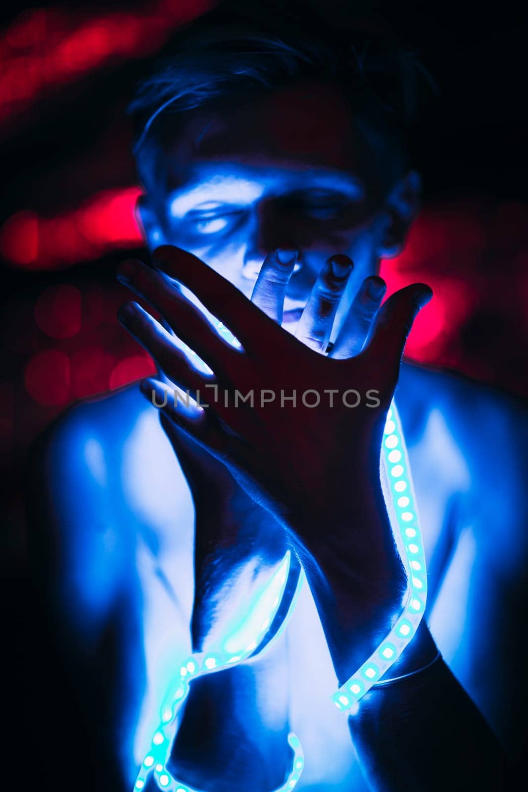 Portrait man Strip Light LED tape on dark color background.