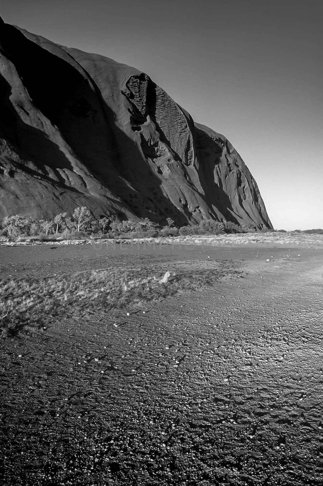 The sun shines down on the footpath at the base of the great monolith Uluru (Ayers Rock) in the heart of Australia's Outback.