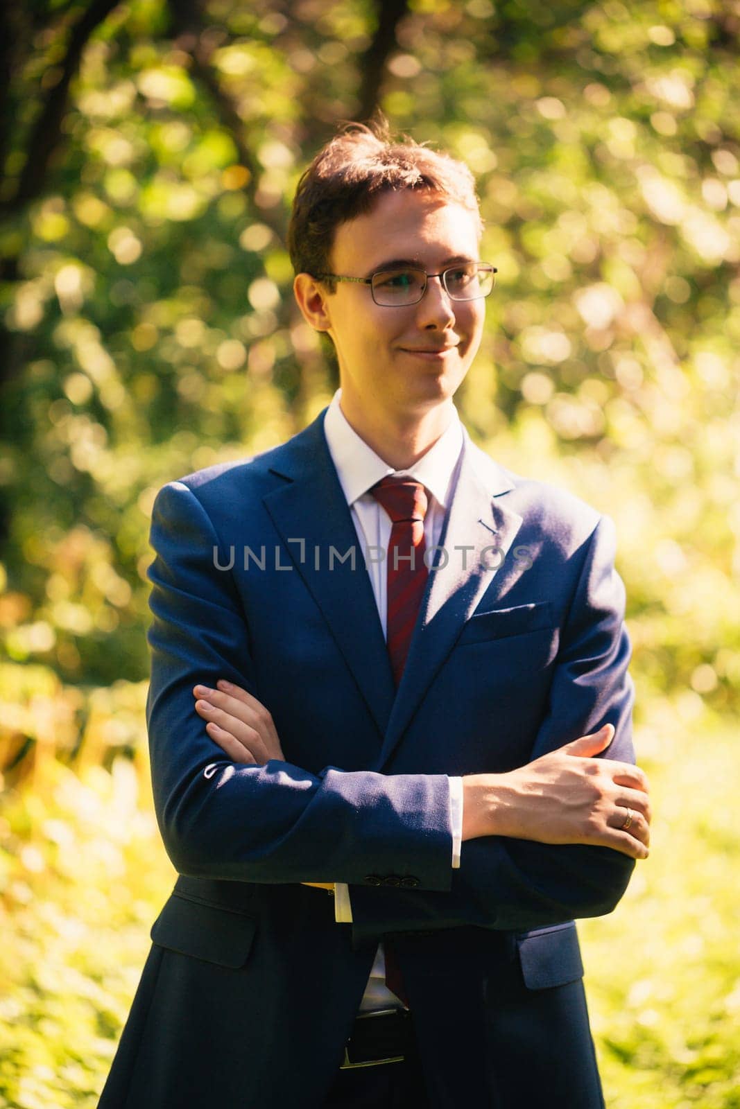 Portrait of the groom in the nature park background.