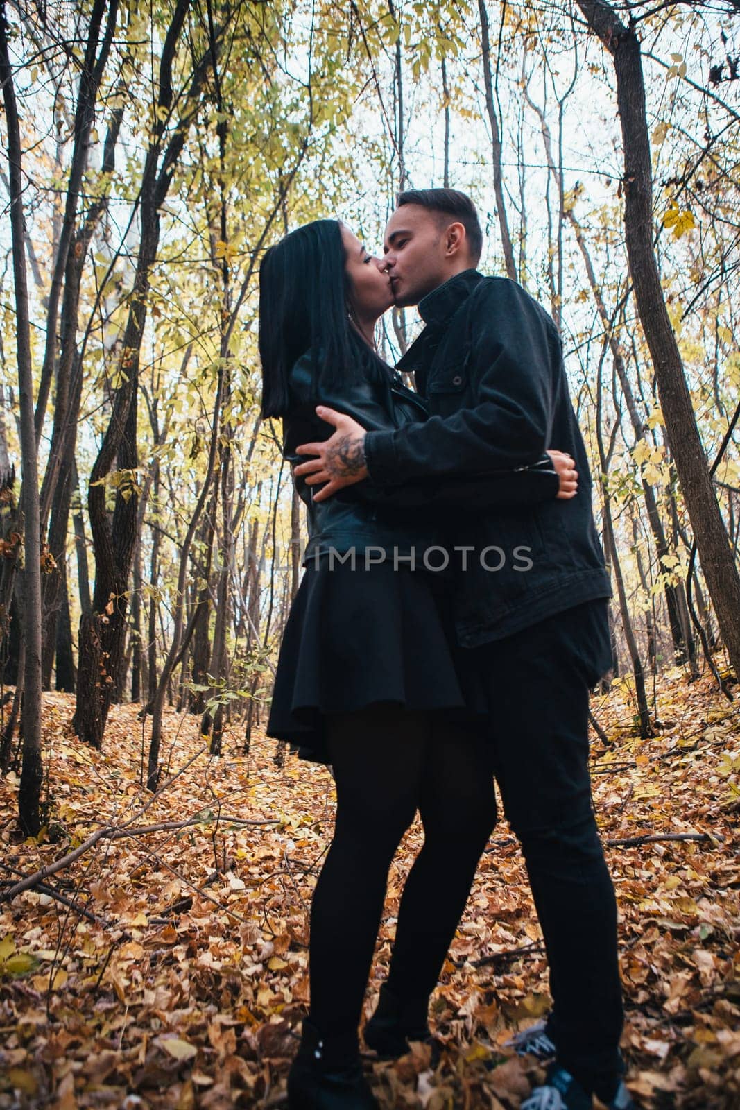 The girl and the guy are walking in the autumn forest.