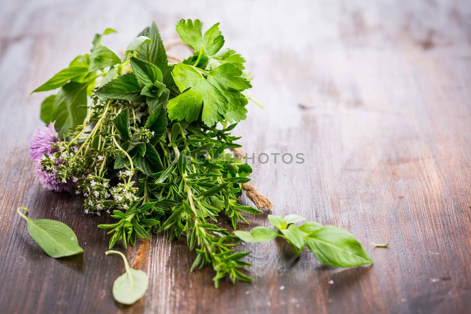 Bunch of different herbs for cooking on wooden background
