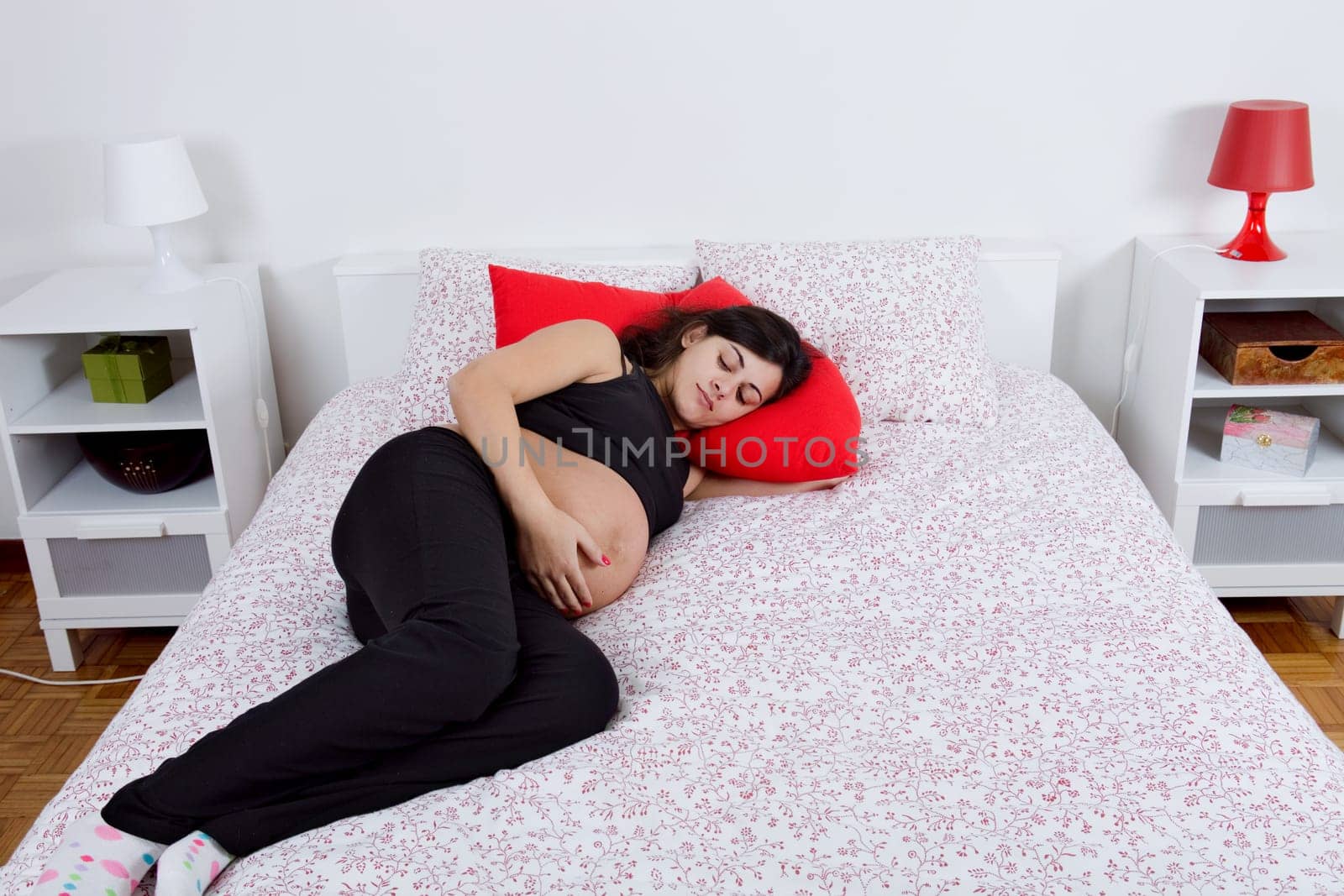 young pregnant woman in bed, focus on the belly