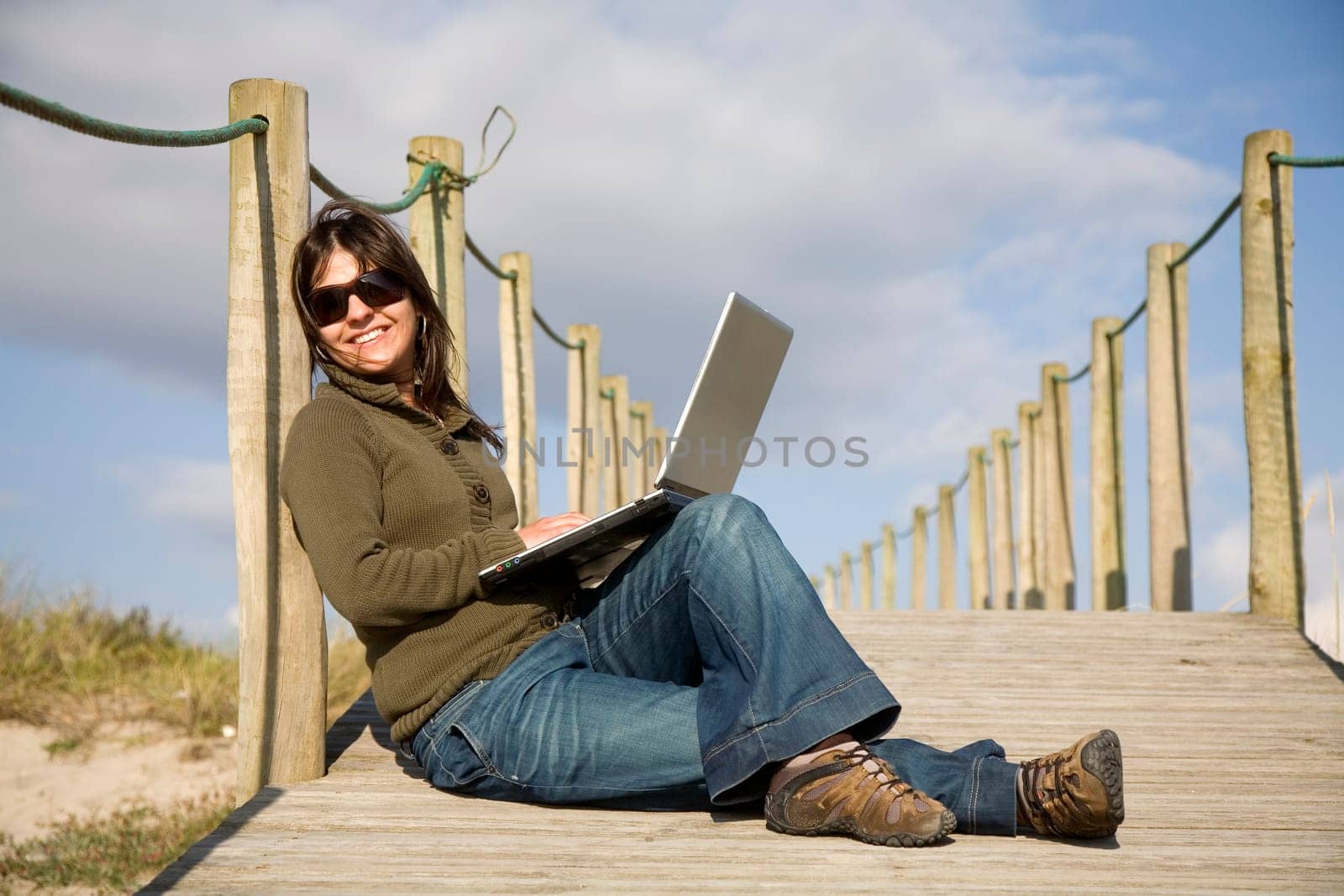 young woman working with computer at the beach