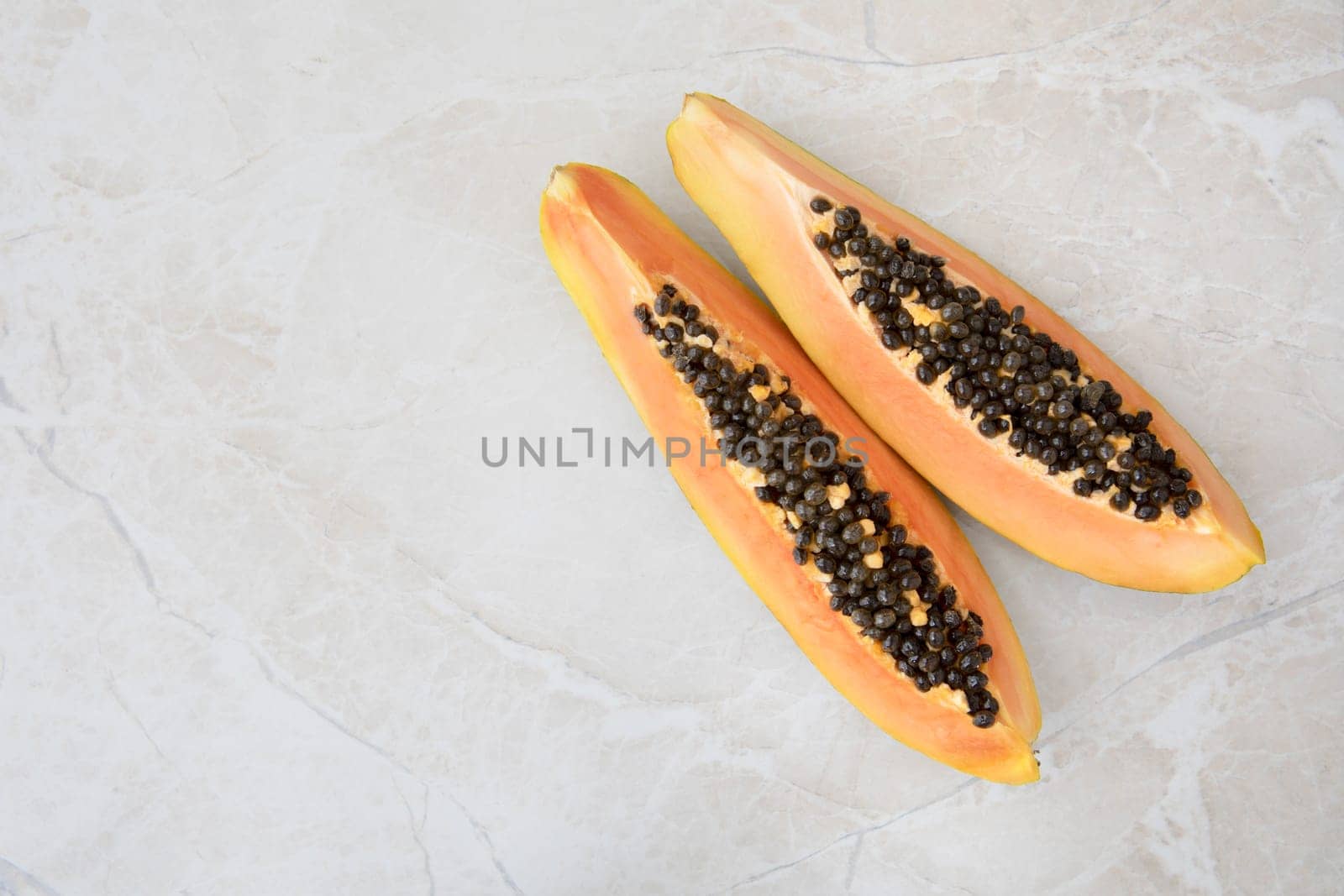 Quarter slices papaya on a marble surface with copy space.