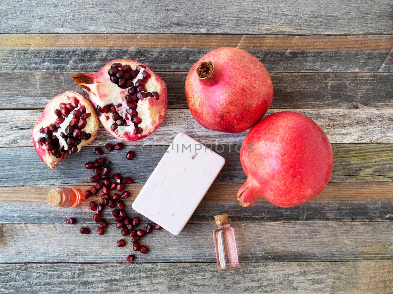 Whole pomegranates with pieces and seeds , and pomegranate soap.  Flat Lay