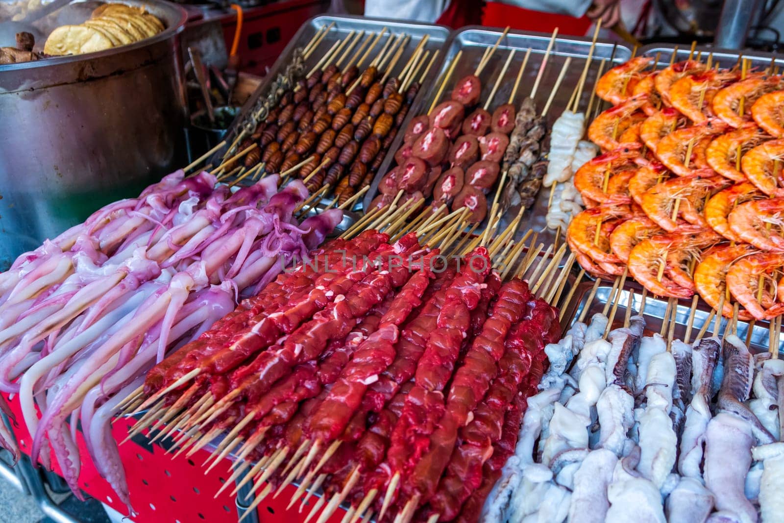 Roasted, fried and raw insects, silkworms, scorpions, bugs, snakes, dog meat, shrimps, octopus on stick as snack street food in China