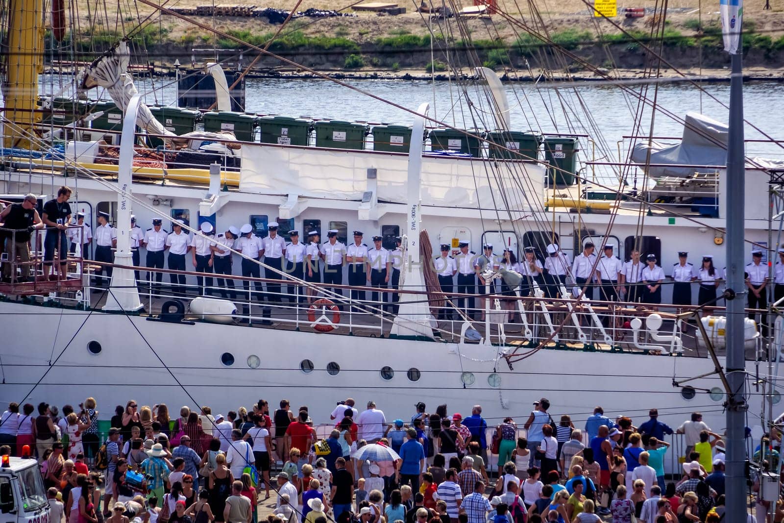 Szczecin, Poland Aug 2013 The Tall Ships Races, sailors standing in a row on tall ship, crowds of visitors in harbour