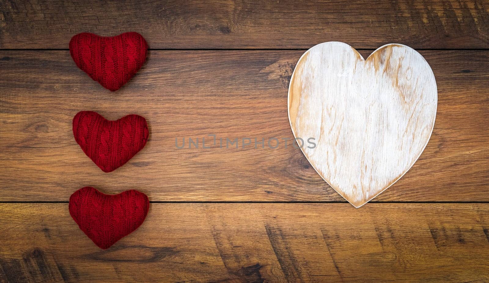 Retro classic Valentines Day cad, large white painted wooden hart, isolated, 3 red cuddle harts, on vintage oak panels, top view