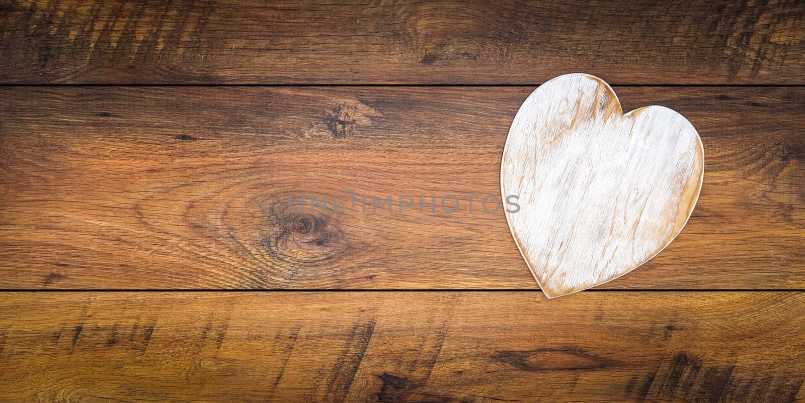 Retro classic Valentines Day cad, large white painted wooden hart isolated and on right side with large copy space on vintage oak panels, top view