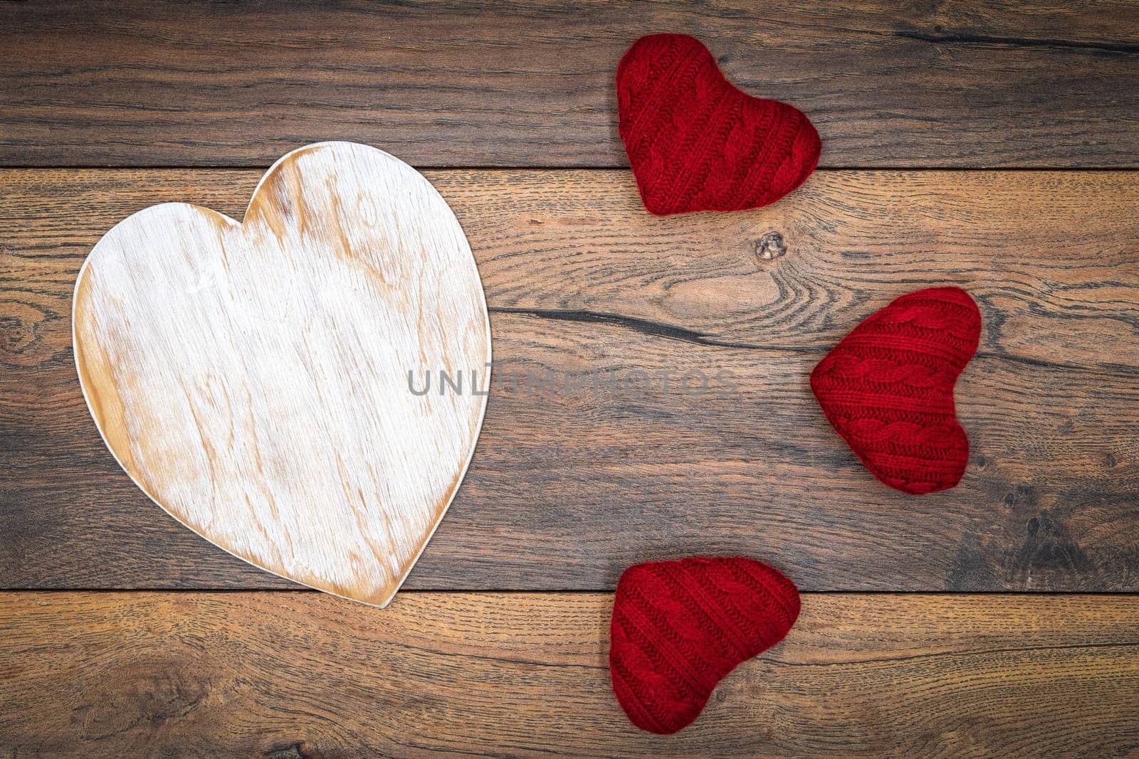 Retro classic Valentines Day cad, large white painted wooden hart, isolated, 3 red cuddle harts, on vintage oak panels, top view