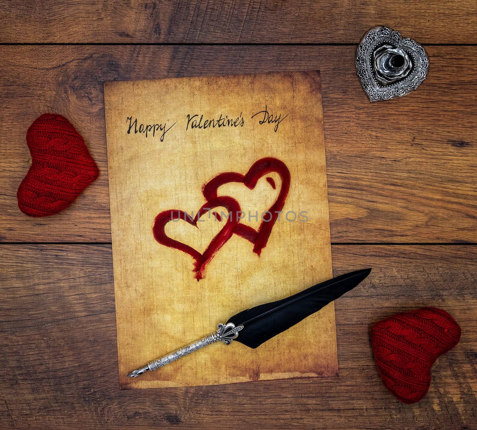 Antique preachment with written Happy Valentines Day, 2 red cuddle hearts, painted hearts, detailed silver quill stand in shape of hart, ornamented silver quill on vintage oak