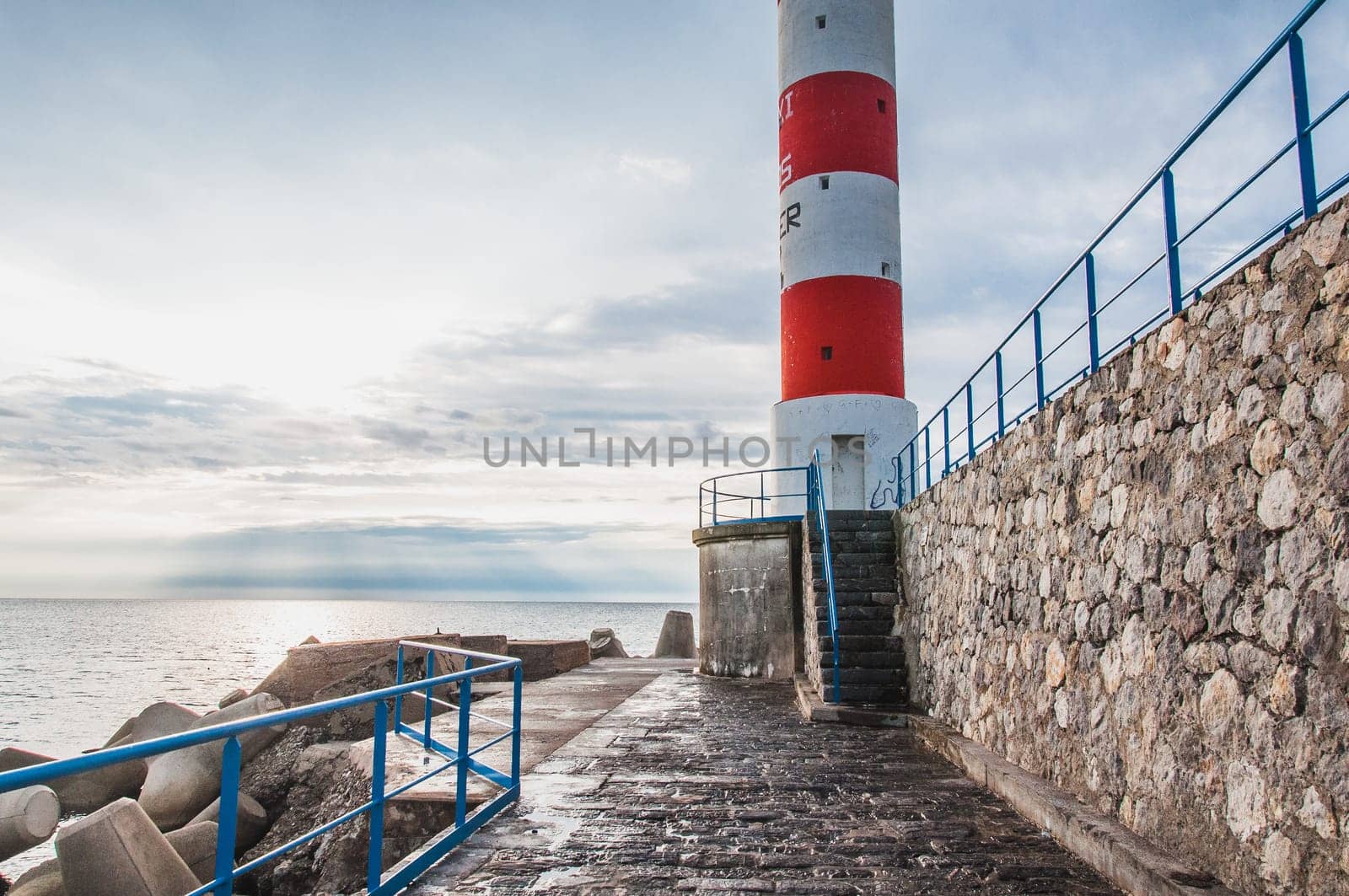 Lighthouse of Port-La-Nouvelle in red and white on cloudy sky in Occitanie, France