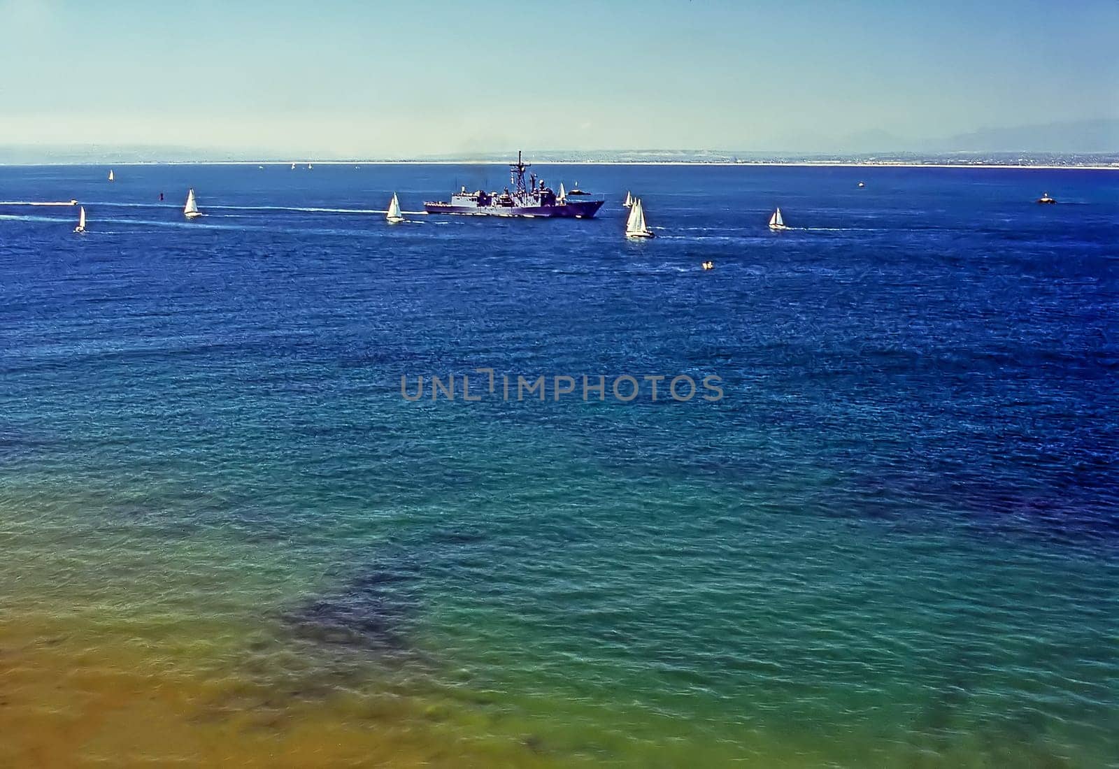 Navy ship and sailboats on Pacific Ocean, California