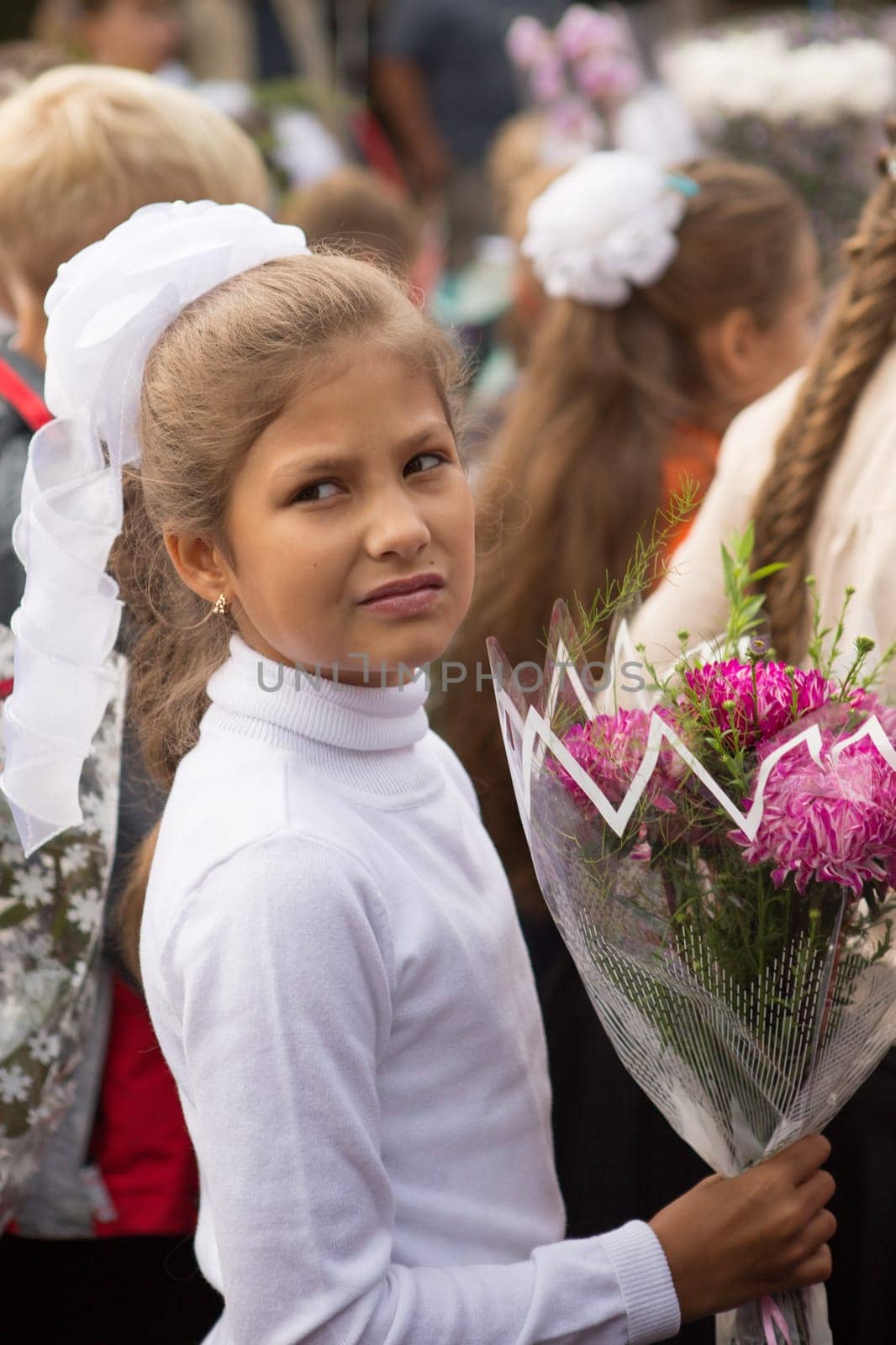 children of the first class of school with a bouquet of flowers celebrate their first school day
