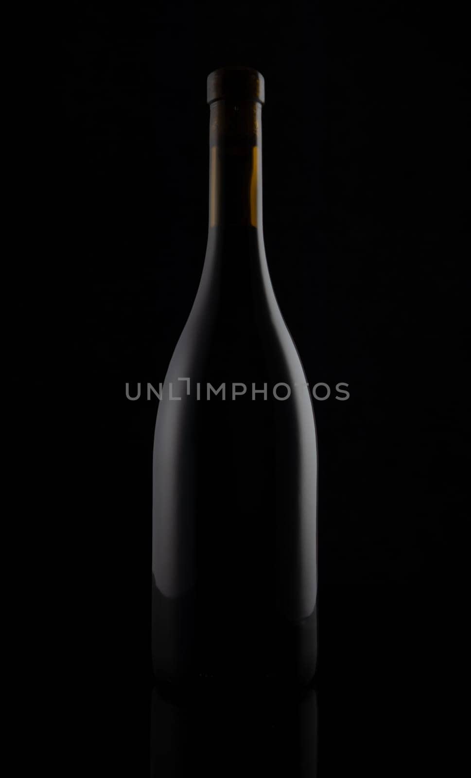 Isolated black matt wine bottle on dark background.