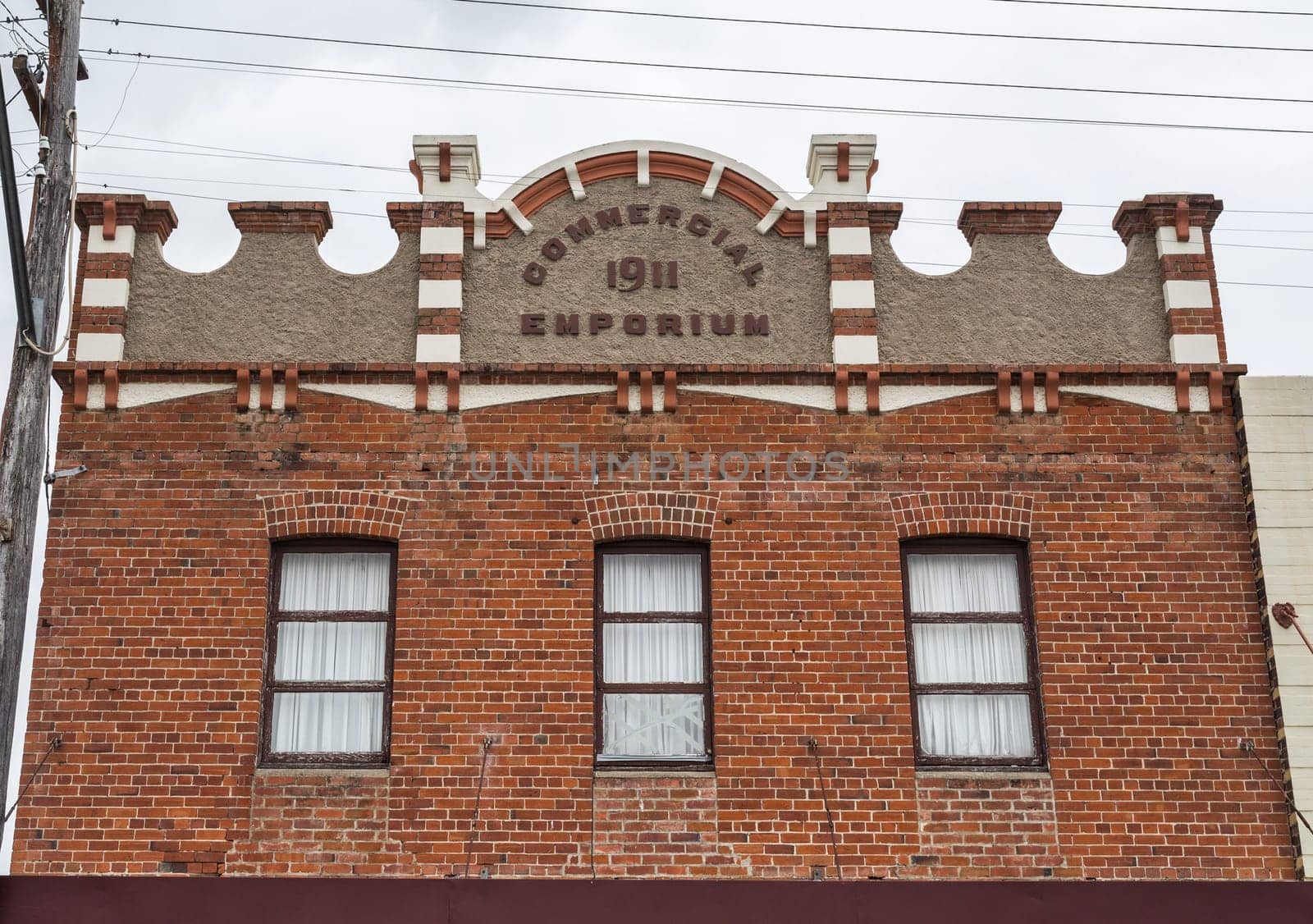 Beautiful facade of a 1911 brick building with rendered parapet and pediment, in Tenterfield, New South Wales, Australia