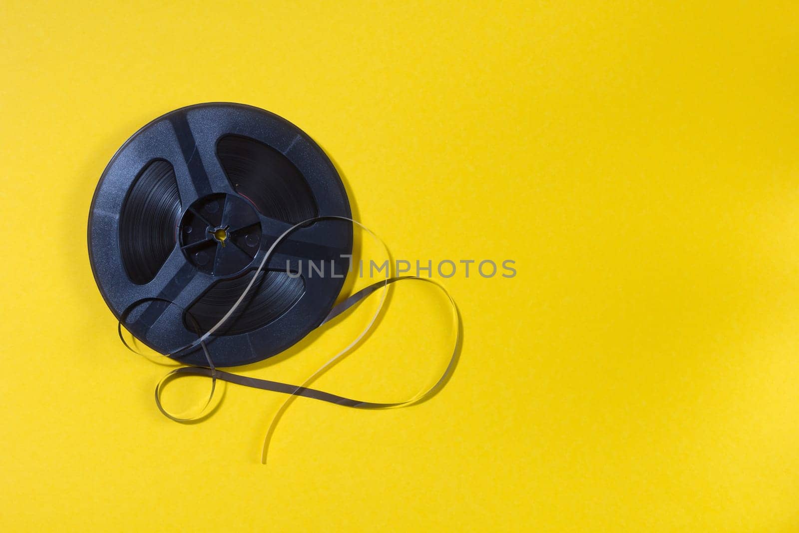 reel-to-reel tape in spool on a yellow background