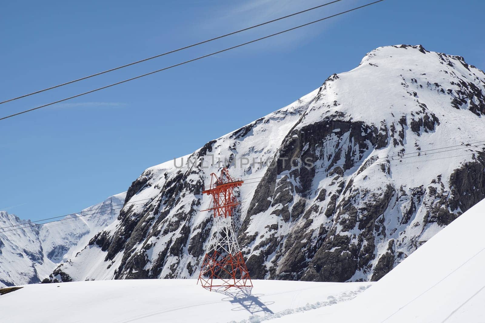 Pylon and ropes of the glacier railway between the towering mountains
