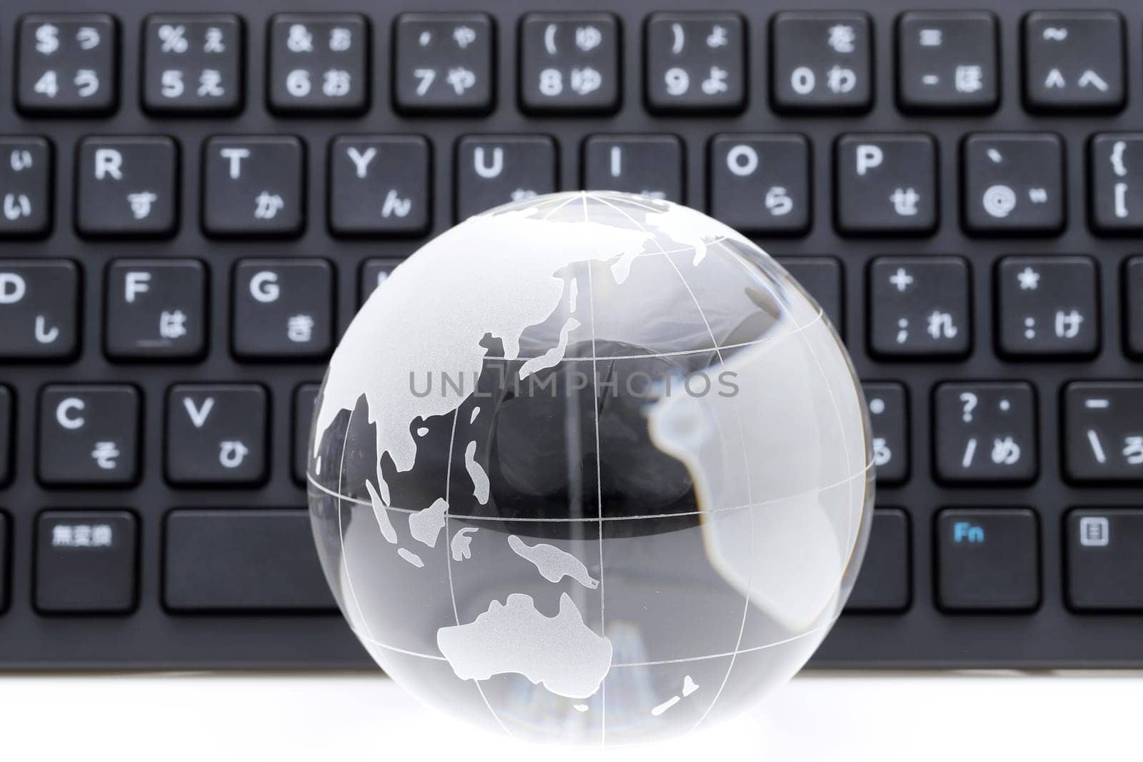 Glass globe ball with keyboard on white background